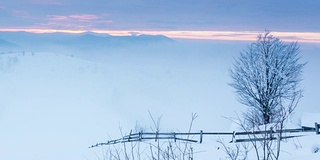 山峰上的雪被风吹走了。冬天的风景。天很冷，下着雪。