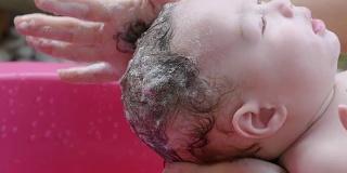 在浴缸里洗澡的亚洲婴儿