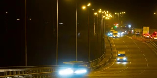 公路交通车辆在夜间时间流逝。汽车在桥上行驶的晚上时间流逝。4 k UHD