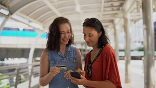 年轻的亚洲女人用信用卡在手机上购物视频素材模板下载