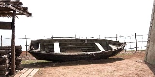 生锈的旧木船。海滩上被遗弃的旧划艇。视频。海滩上的一条旧船