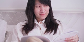 泰国美女是读书在她的卧室在周末与她的休闲活动