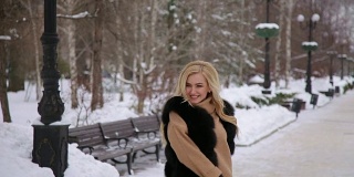 欢笑的年轻女子有乐趣在冬季公园。