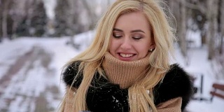 年轻快乐的女孩在公园里吹雪。