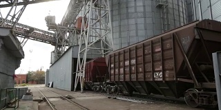 以农作物作为货物运输的货运列车在近海大型粮食码头行驶。将粮食从铁路车厢卸到升降机。粮食中转设施枢纽仓