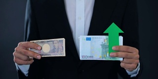 男子持有现钞，欧元相对日元升值，财务预测