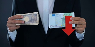 男子持有现钞，欧元相对日元下跌，财务预测