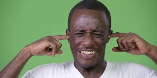 年轻的非洲男子用手捂住耳朵，以免被噪音吵醒