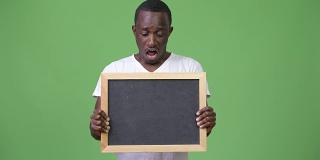 年轻的非洲人展示黑板，看起来很震惊