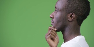 在绿色背景下思考的年轻非洲人的侧面视图