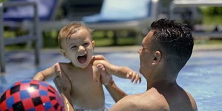爸爸在游泳池里抬宝宝上下