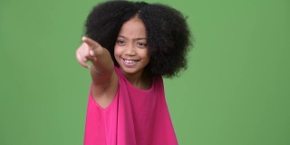年轻可爱的非洲女孩有非洲式的头发，笑着指着手指