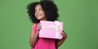 年轻可爱的非洲女孩与非洲发式拿着礼盒