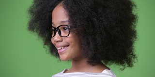 侧面的年轻可爱的非洲女孩与非洲式头发微笑