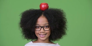 年轻快乐的非洲女孩，有着非洲式的头发，头顶有苹果