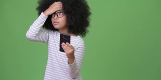 年轻可爱的非洲女孩与非洲发型使用电话和头痛