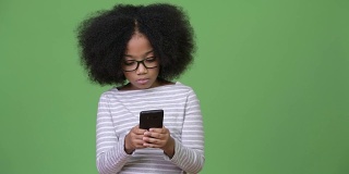 年轻可爱的非洲女孩与非洲发型使用电话