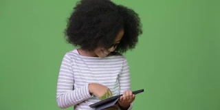年轻可爱的非洲女孩与非洲发式使用数字平板电脑