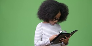 年轻可爱的非洲女孩与非洲发式研究在绿色的背景