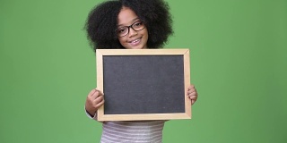 年轻可爱的非洲女孩与非洲发式拿着黑板