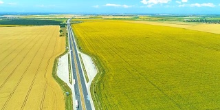 超宽航拍无人机下降在高速公路和向日葵小麦农田