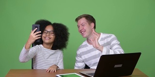 年轻的非洲女孩和年轻的斯堪的纳维亚男子一起使用电子产品
