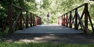 一个男人在公园里骑自行车。在夏天的时间。