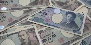 近距离观察日本硬币日元下跌的1000和10000日元纸币背景。超级慢动作120 fsp带声音。