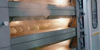 在商业厨房热气腾腾的烤箱和新鲜的面包。
