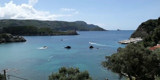 科孚岛(希腊)古奥卡斯特里萨镇海湾的鸟瞰图。森林，房屋和海岸线。船在泻湖附近行驶。