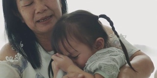 泰国小女孩在妈妈和弟弟旁边哭，失望和愤怒的感觉
