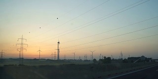 在日落时分，在高速公路上驾驶着风车
