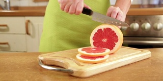 女人的手在切葡萄柚