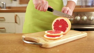 女人的手在切葡萄柚视频素材模板下载
