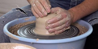 陶工在陶工转盘上做花瓶。慢动作