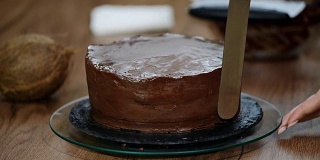 糕点师在蛋糕上涂上巧克力奶油。