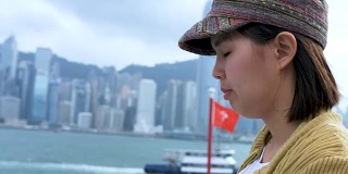 在香港维多利亚港使用智能手机的女性游客