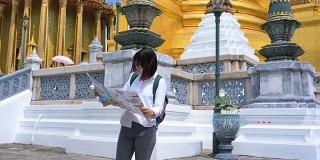 年轻的女游客探索城市地图，而旅行在泰国曼谷