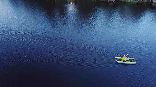 鸟瞰图上的人谁在一个湖上的脚踏双体船，水上自行车