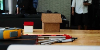 建筑，建筑，建筑，房地产和家的概念-近距离居住的房子模型在桌子上与建筑师或房地产经纪人的背景与潘左
