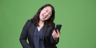 成熟美丽的亚洲女商人使用电话和得到好消息