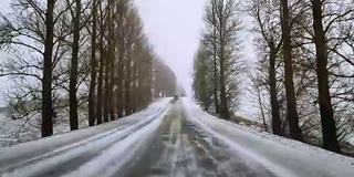 在可怕的多雪多风的天气里在高速公路上开车。透过挡风玻璃的视野-驾驶员视角。移动视频。