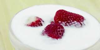 健康草莓在透明杯中配以白色酸奶，概念健康水果食品营养，移动相机移动