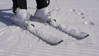 在一个阳光明媚的日子里，滑雪者踩进滑雪绑定与他的滑雪靴视频素材模板下载