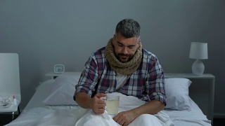 病人在床上咳嗽，喝退热茶治疗发烧、流感流行视频素材模板下载