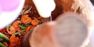 女人的手煮辣青木木瓜沙拉，胡萝卜和香草在木臼，街头小吃小贩做泰式木瓜沙拉，泰式食物泰式沙拉。1920年视频x2080