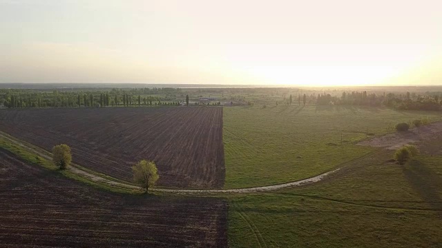 空中全景视频全高清从无人机，鸟瞰抽象几何形式的废弃跑道，森林和农田在夏季傍晚日落。