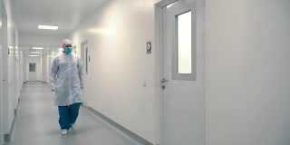 医院的工作人员穿过走廊进入一间病房