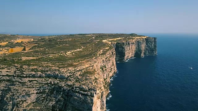 风景鸟瞰图戏剧性的高悬崖与美丽的海景。游艇在海上航行。无人机俯视图拍摄的危险石崖。Gozo岛、马耳他