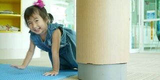 亚洲小女孩在图书馆玩耍和学习